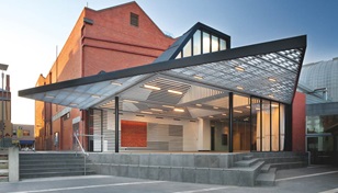 The roof cleverly folds in on itself to create multiple facets of light within, and overhangs on the outside where it forms two large awnings that address both the plaza and adjacent historic Huyghue House